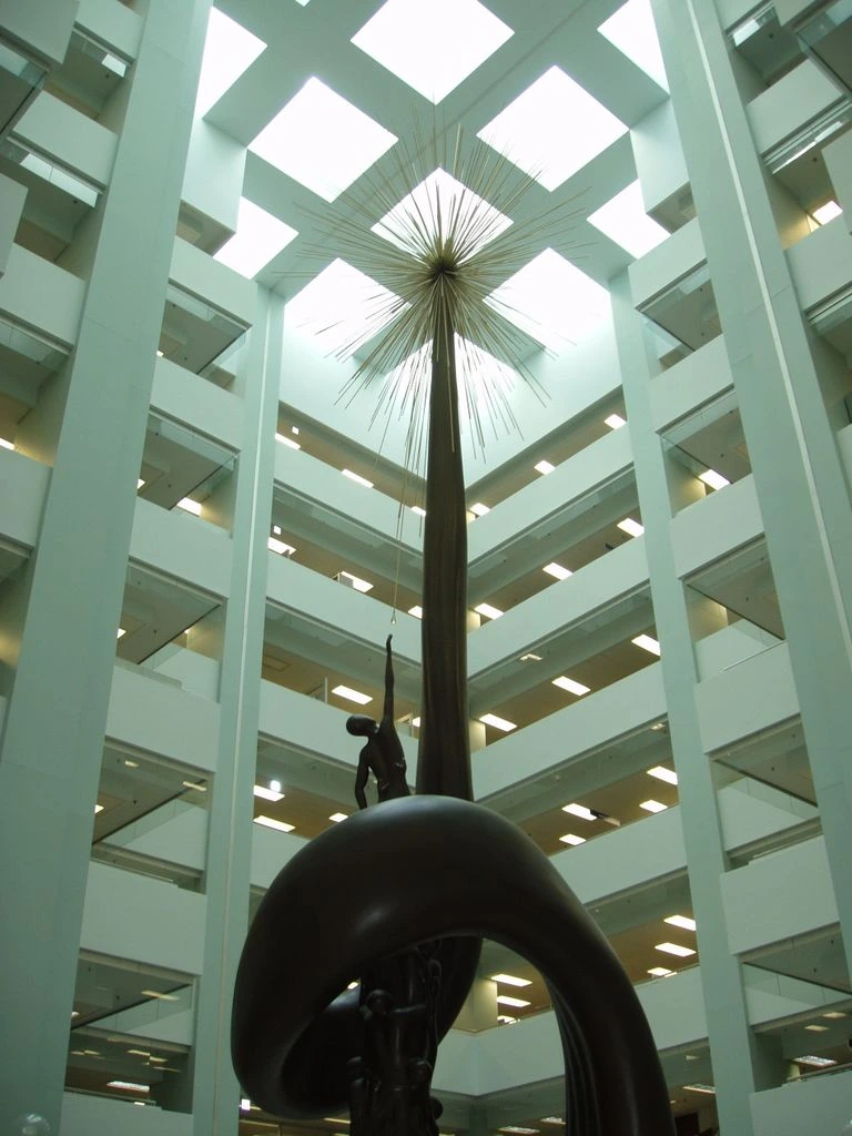 Sculptural bronze chandelier installation in a modern timber office atrium
